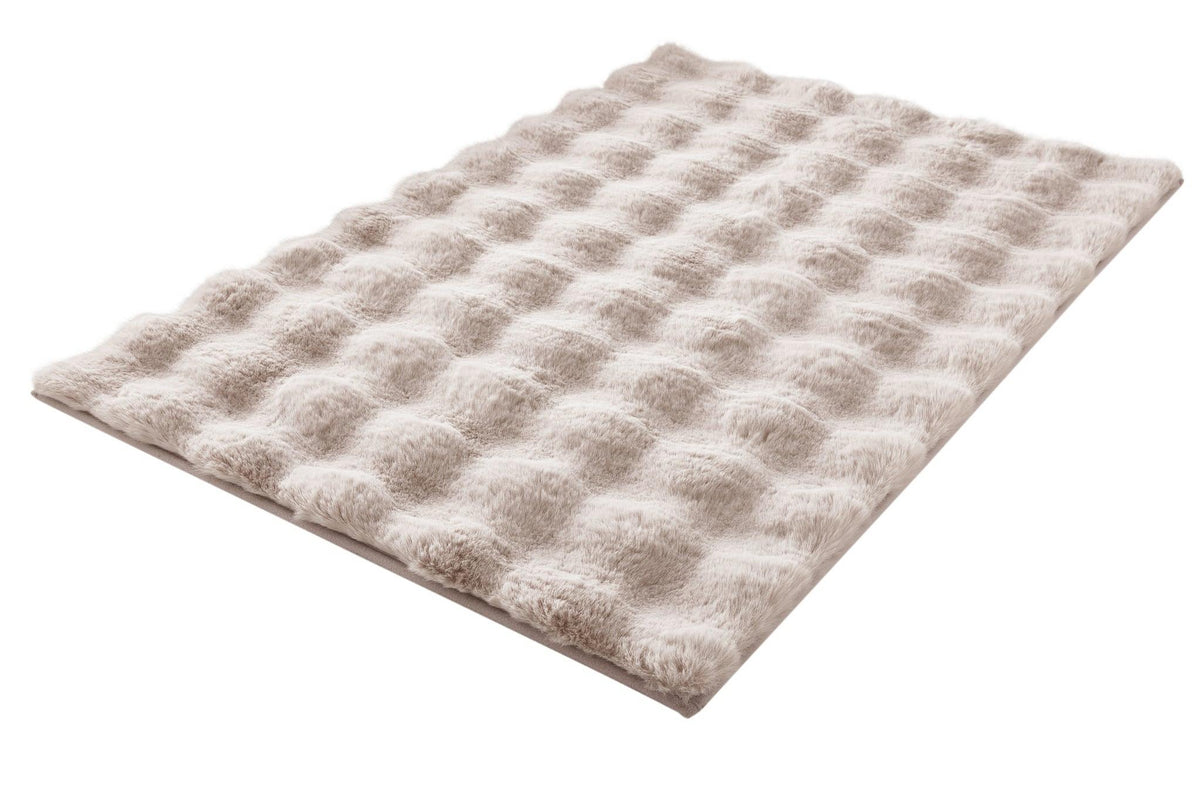 Beige, flauschige Badematte mit gleichmäßiger, gewellter Oberfläche