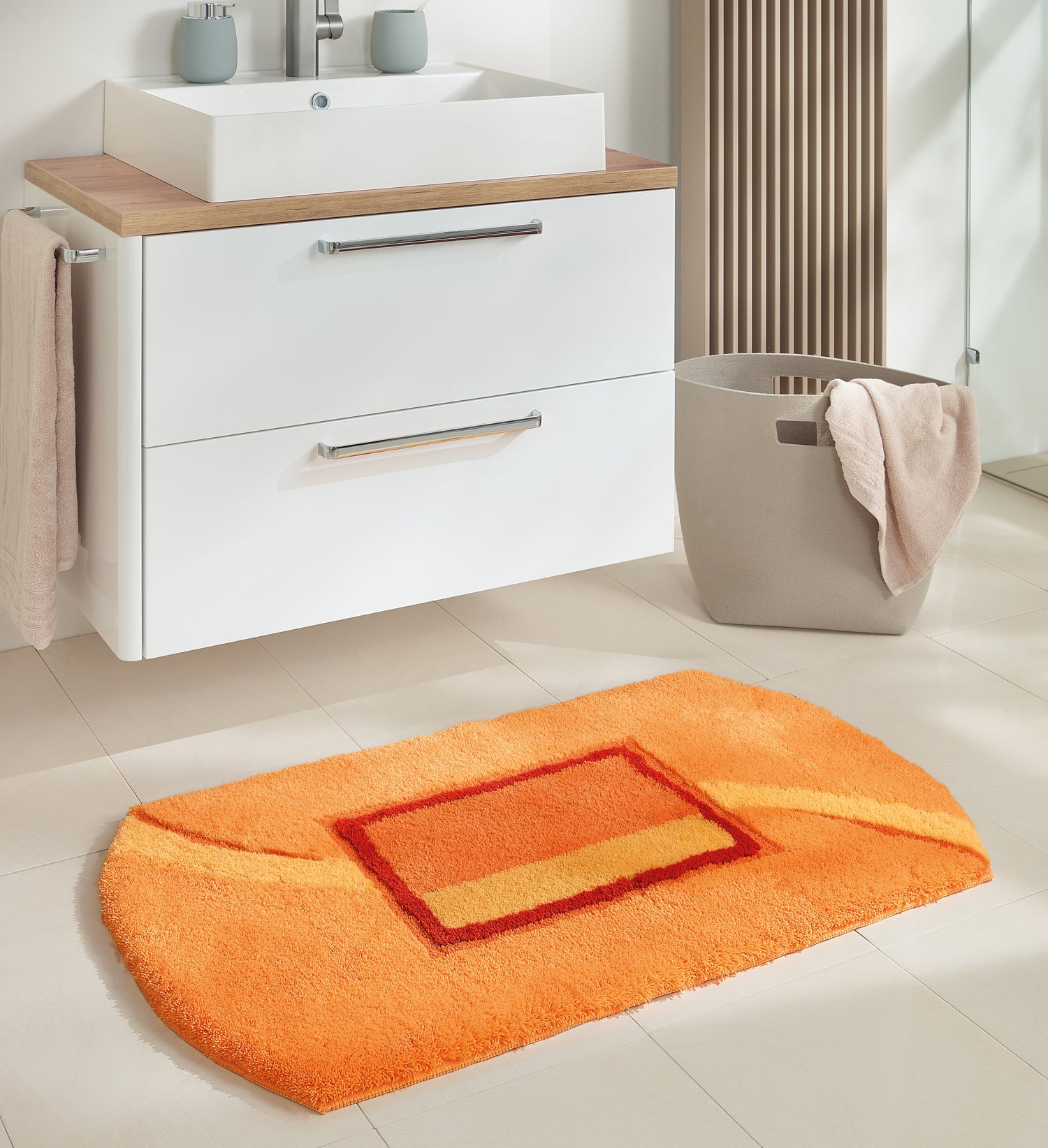 Orange Badematte Kleine Wolke Creativo Angelo vor weißem Waschbeckenunterschrank im Bad.