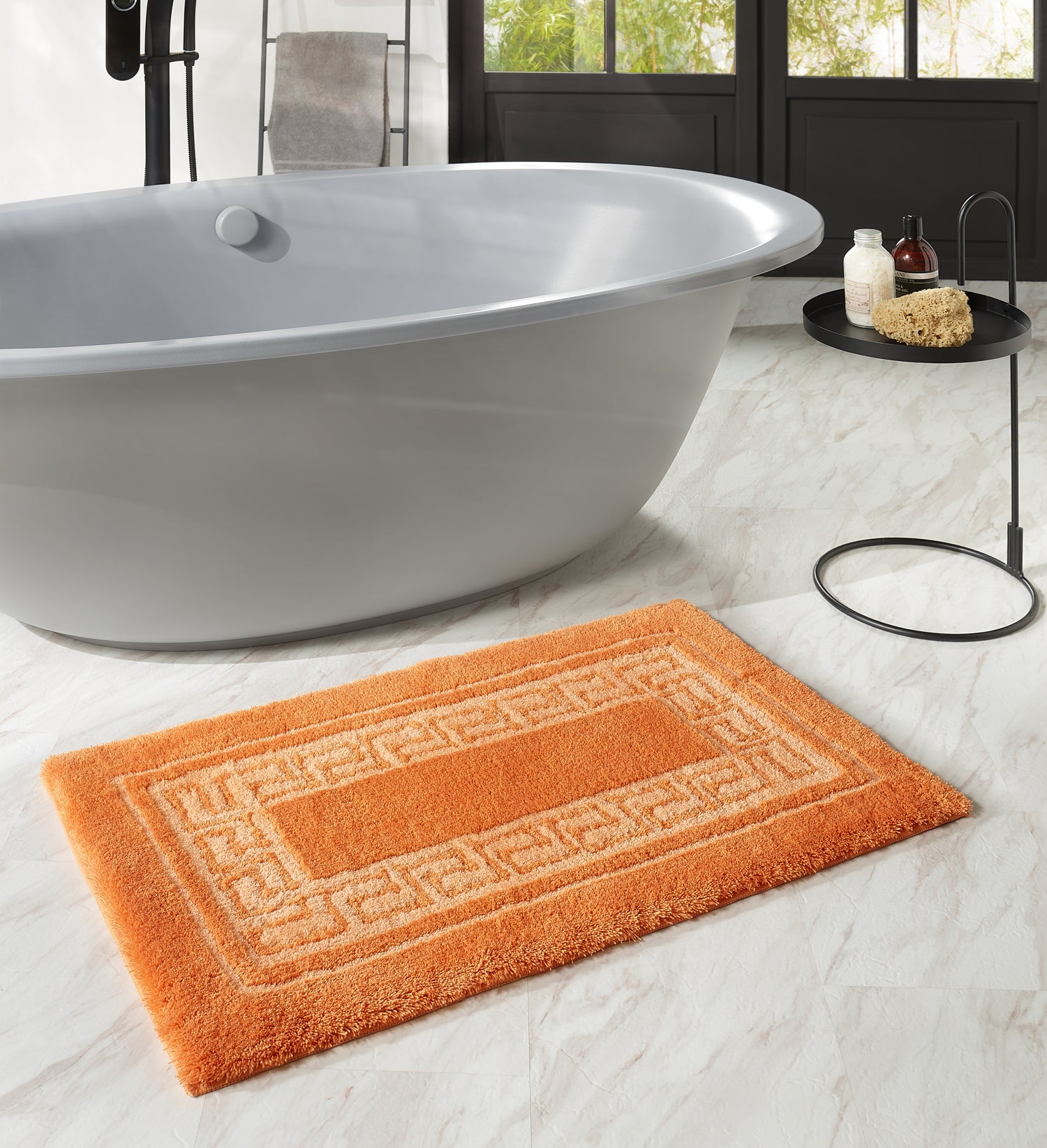 Oranger Kleine Wolke Creativo Meandro Badteppich liegt vor freistehender Badewanne im modernen Bad.