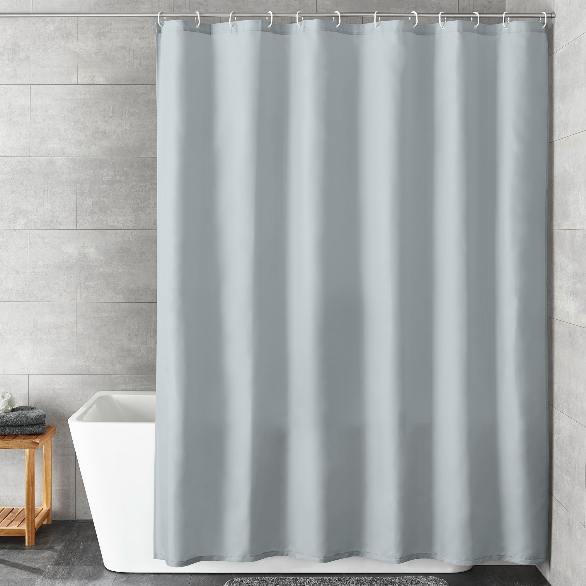 Grauer Kleine Wolke Duschvorhang hängt in modernem Bad vor weißer Wanne und Holzhocker.