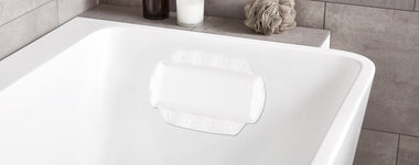 Weiße Badewanne mit rutschfestem Wannenkissen und Badaccessoires