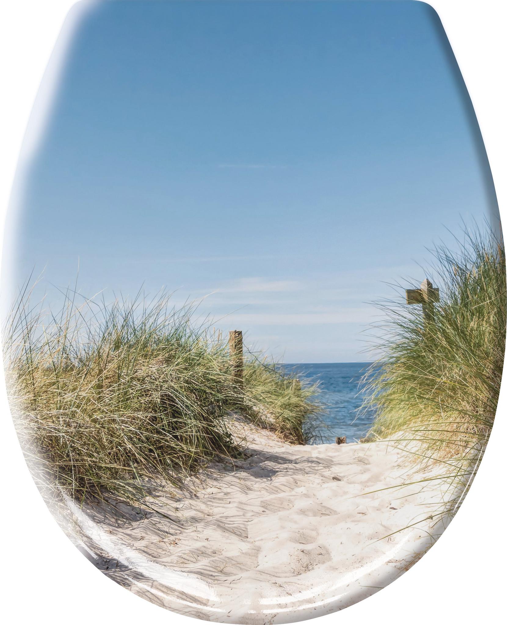 Sandweg durch Dünen zum Meer unter blauem Himmel mit hohem Dünengras