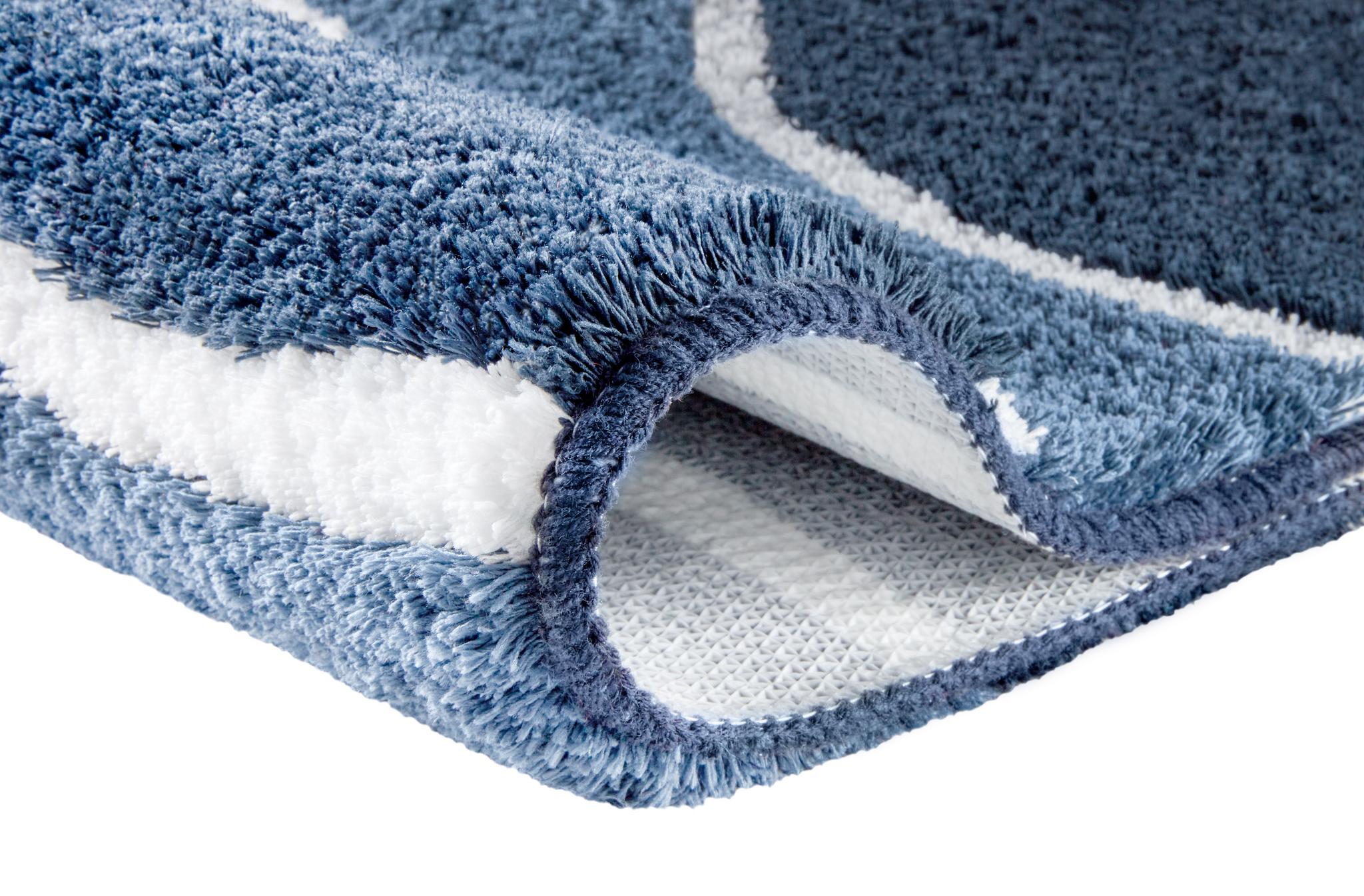 Blauer flauschiger Badteppich mit weißem Muster im Detail.