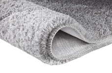 Grauer Hochflor-Teppich mit rutschhemmender Unterseite.