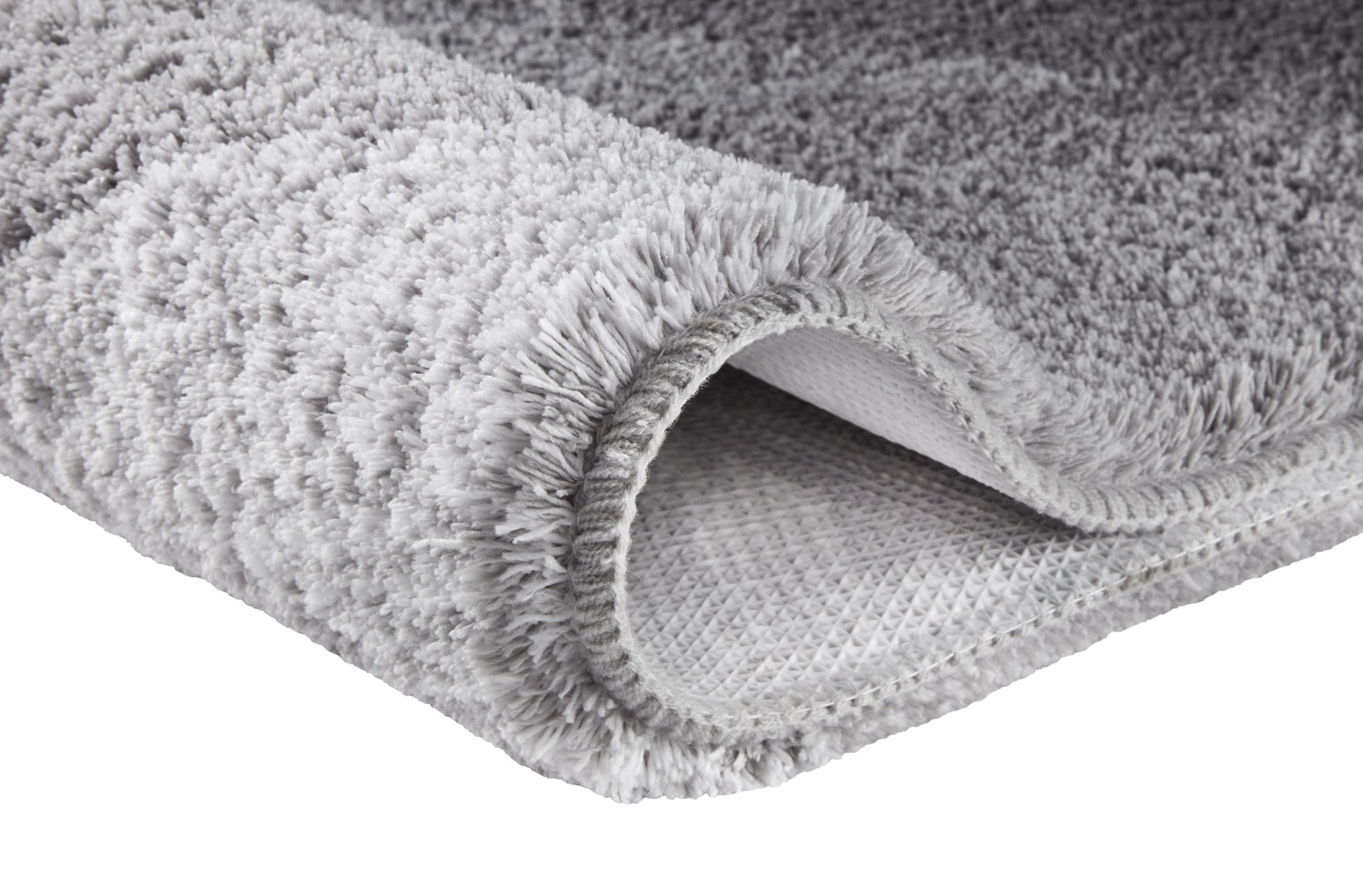 Grauer Hochflor-Teppich mit rutschhemmender Unterseite.