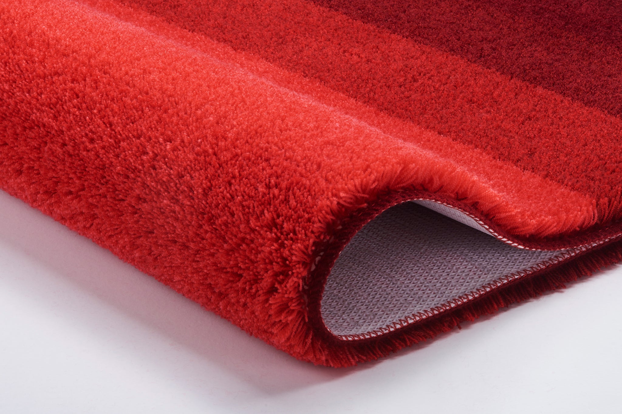 Roter, flauschiger Badteppich mit rutschfester Unterseite in Nahaufnahme