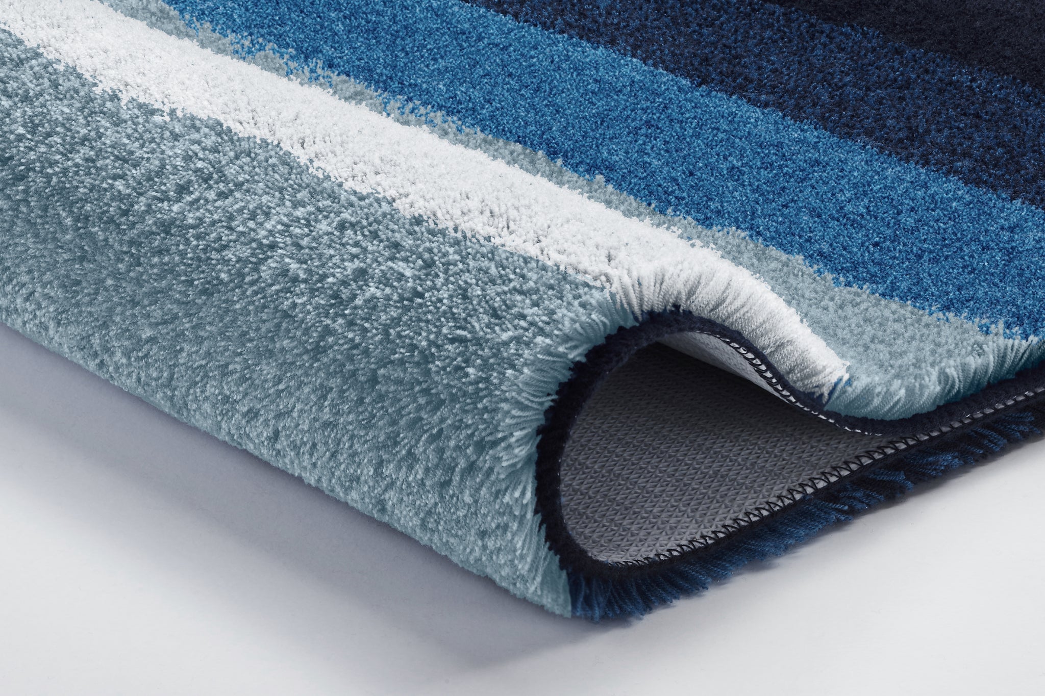 Nahaufnahme eines gestreiften Badteppichs in Blau- und Grautönen