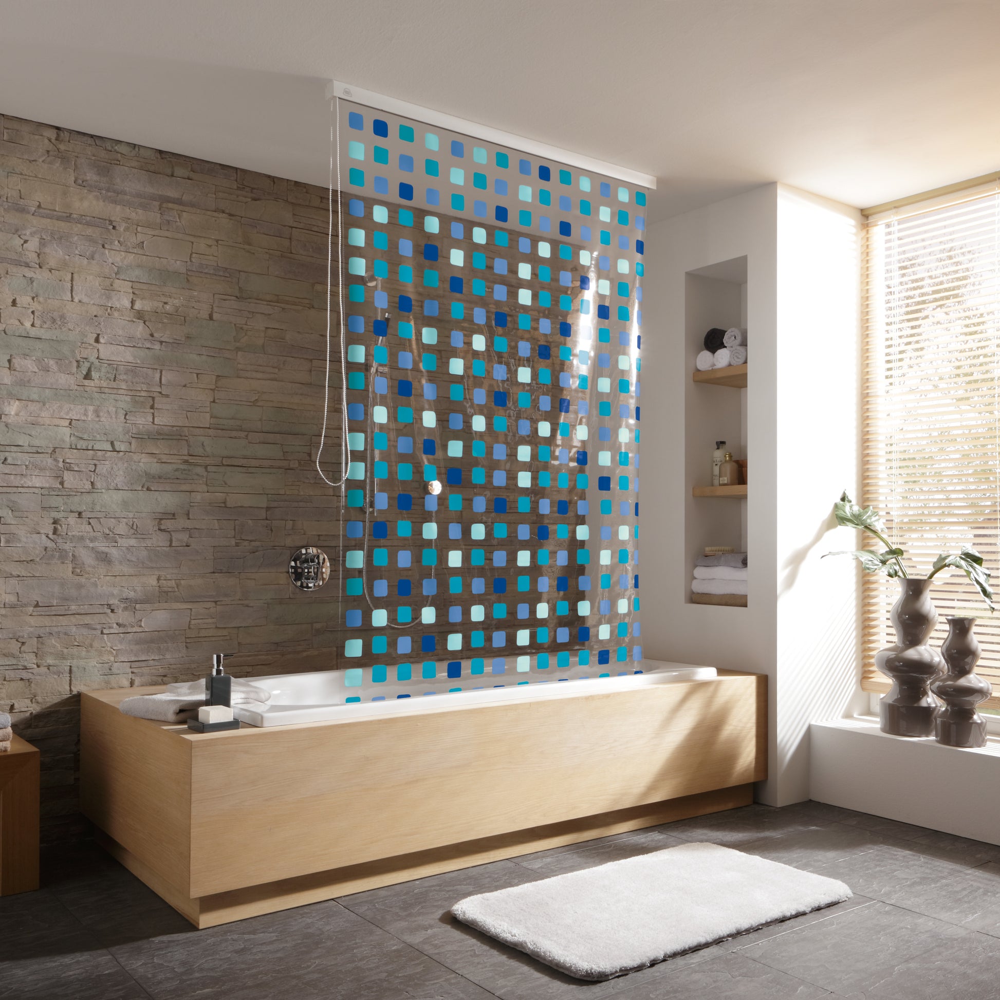 Bad mit Wanne und Duschvorhang Blue 128 x 240 cm für Duschrollo-Leerkassette vor Steinwand.