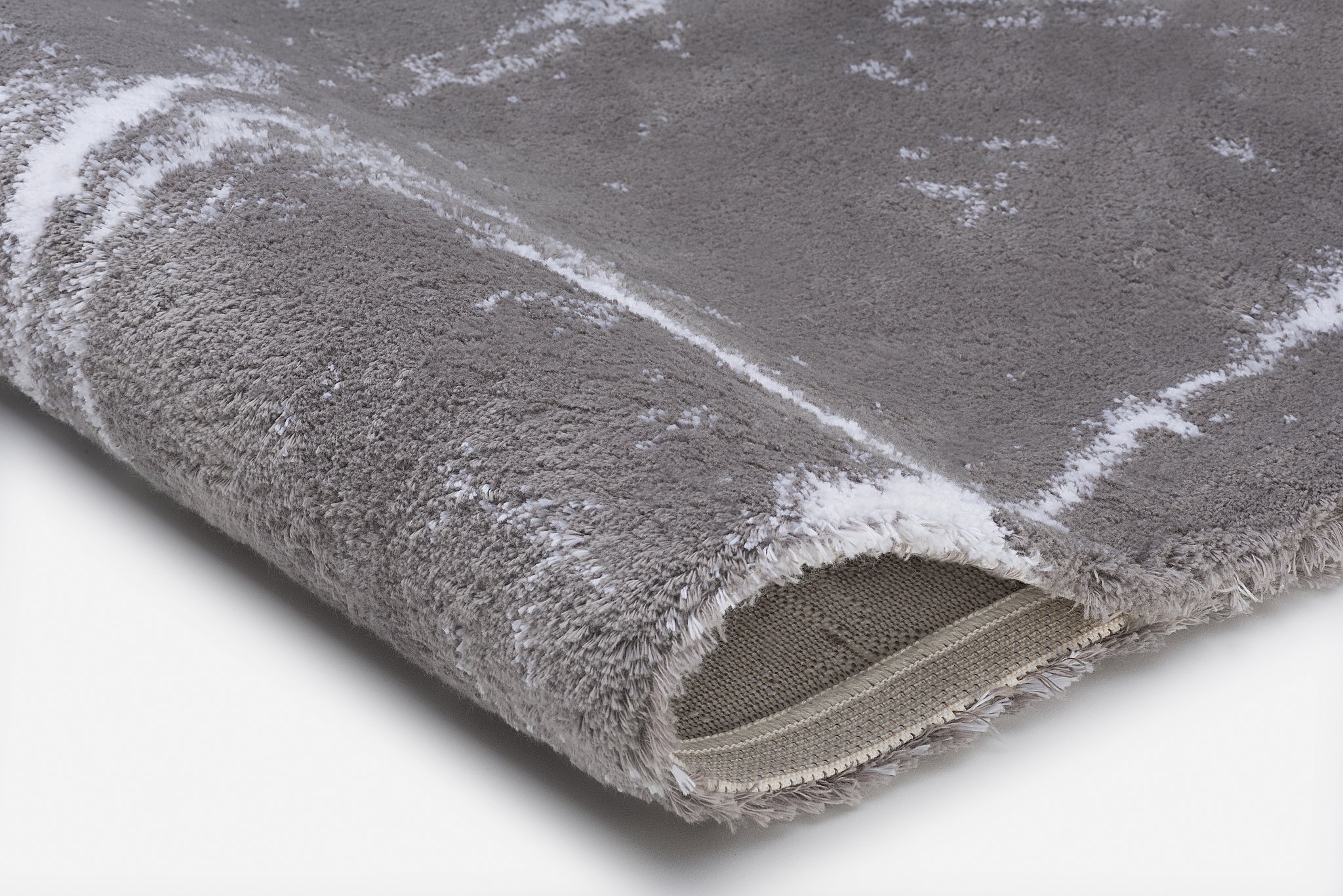 Grauer, flauschiger Badteppich mit umgeschlagener Ecke in Nahaufnahme