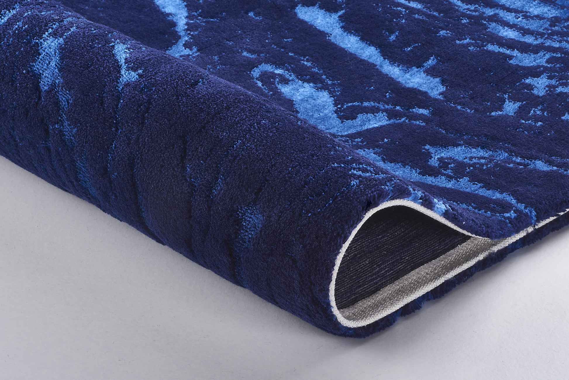 Dunkelblauer Badteppich mit hellblauem Wellenmuster, Detailansicht