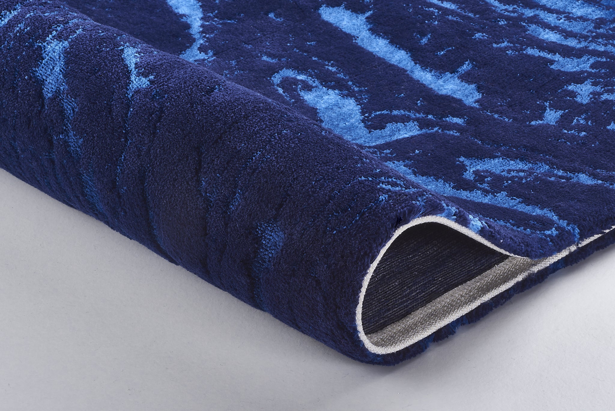 Dunkelblauer Badteppich mit hellblauem Wellenmuster, Detailansicht