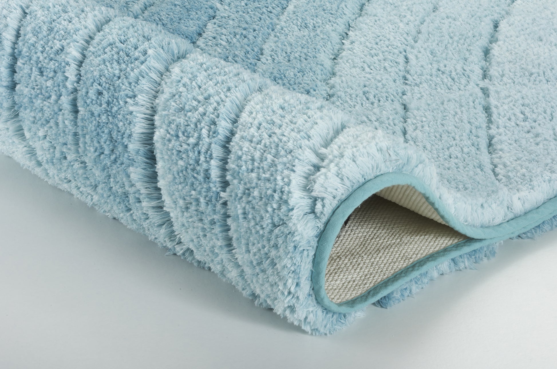 Hellblauer weich strukturierter Badteppich, Detailansicht der Kante