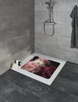 Bodengleiche Dusche mit grauen Fliesen und Duschmatte mit Blumenmotiv