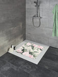 Dusche mit grauen Fliesen und floraler Duschmatte in Rosa-Grün Tönen