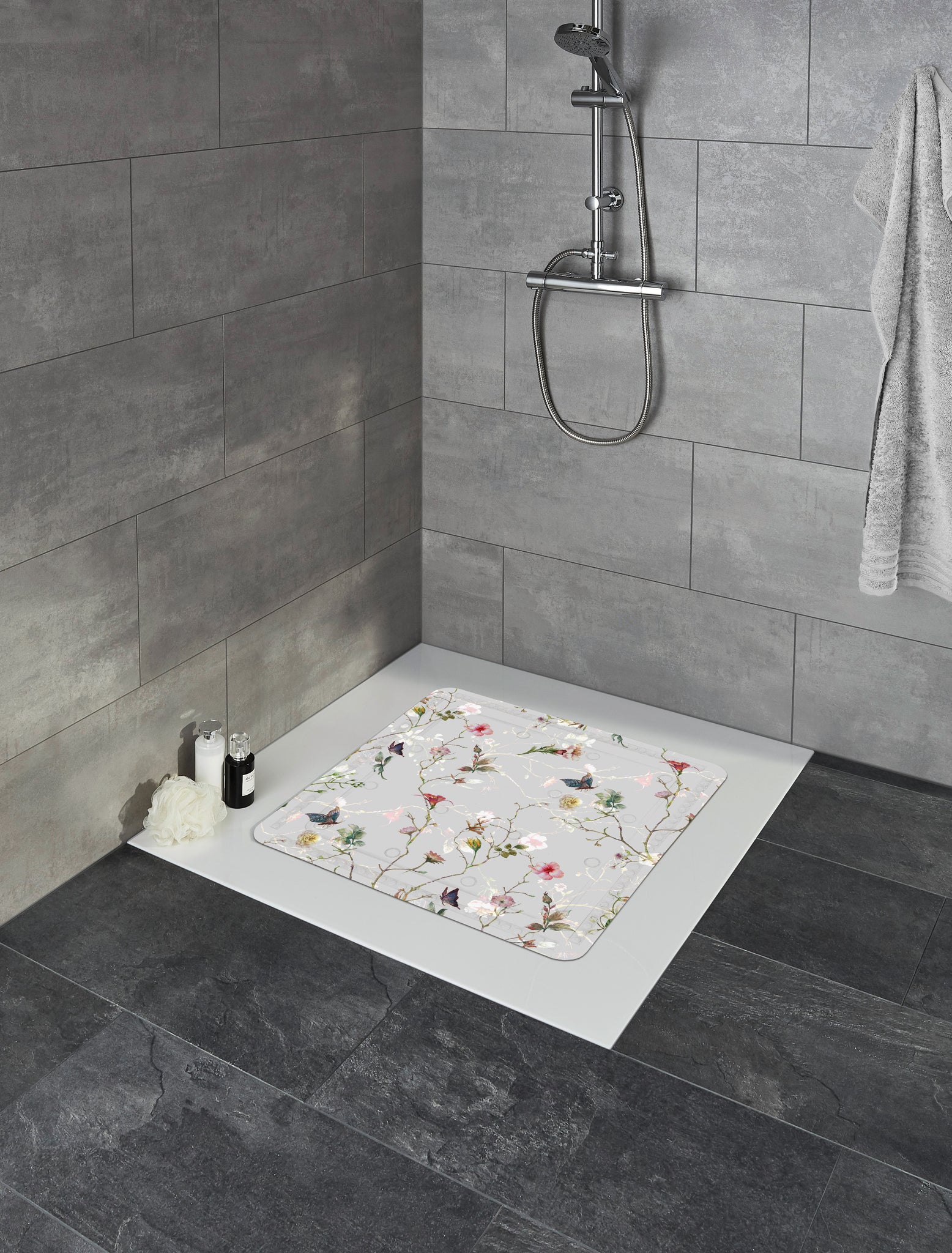 Duscheinlage FLORES Multicolor 55 x 55 cm liegt in weißer Dusche mit grauen Fliesen.