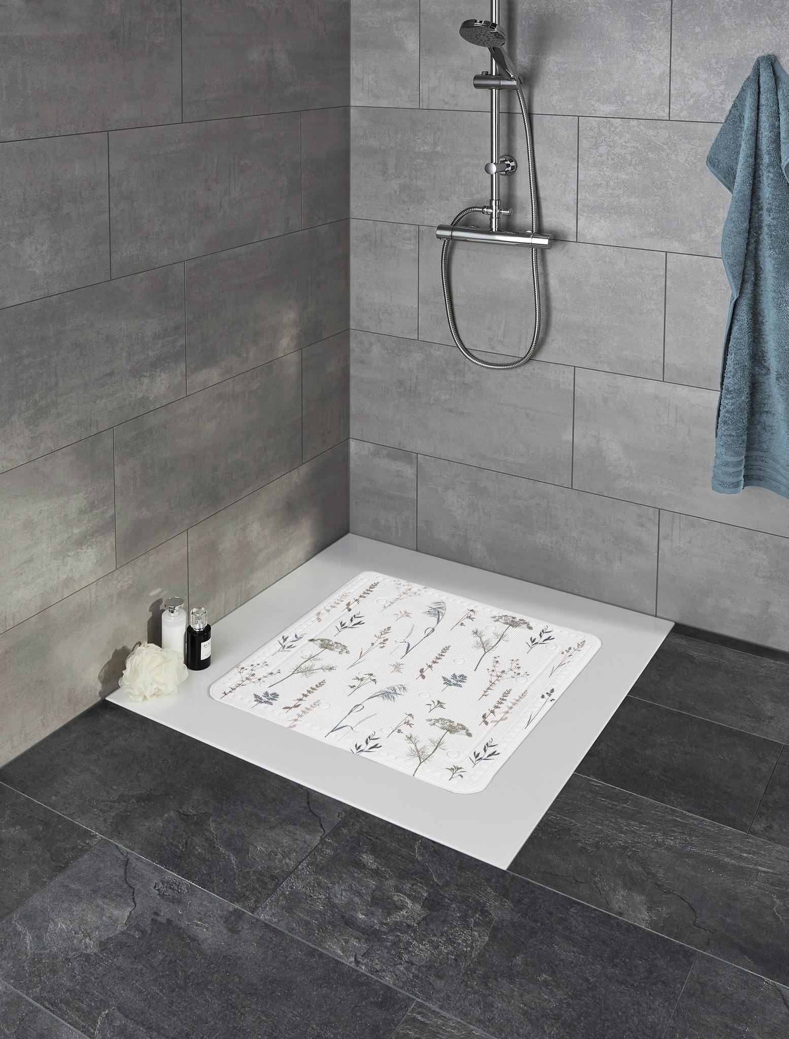 Begehbare Dusche mit grauen Fliesen und Duschmatte mit Blütenmotiv