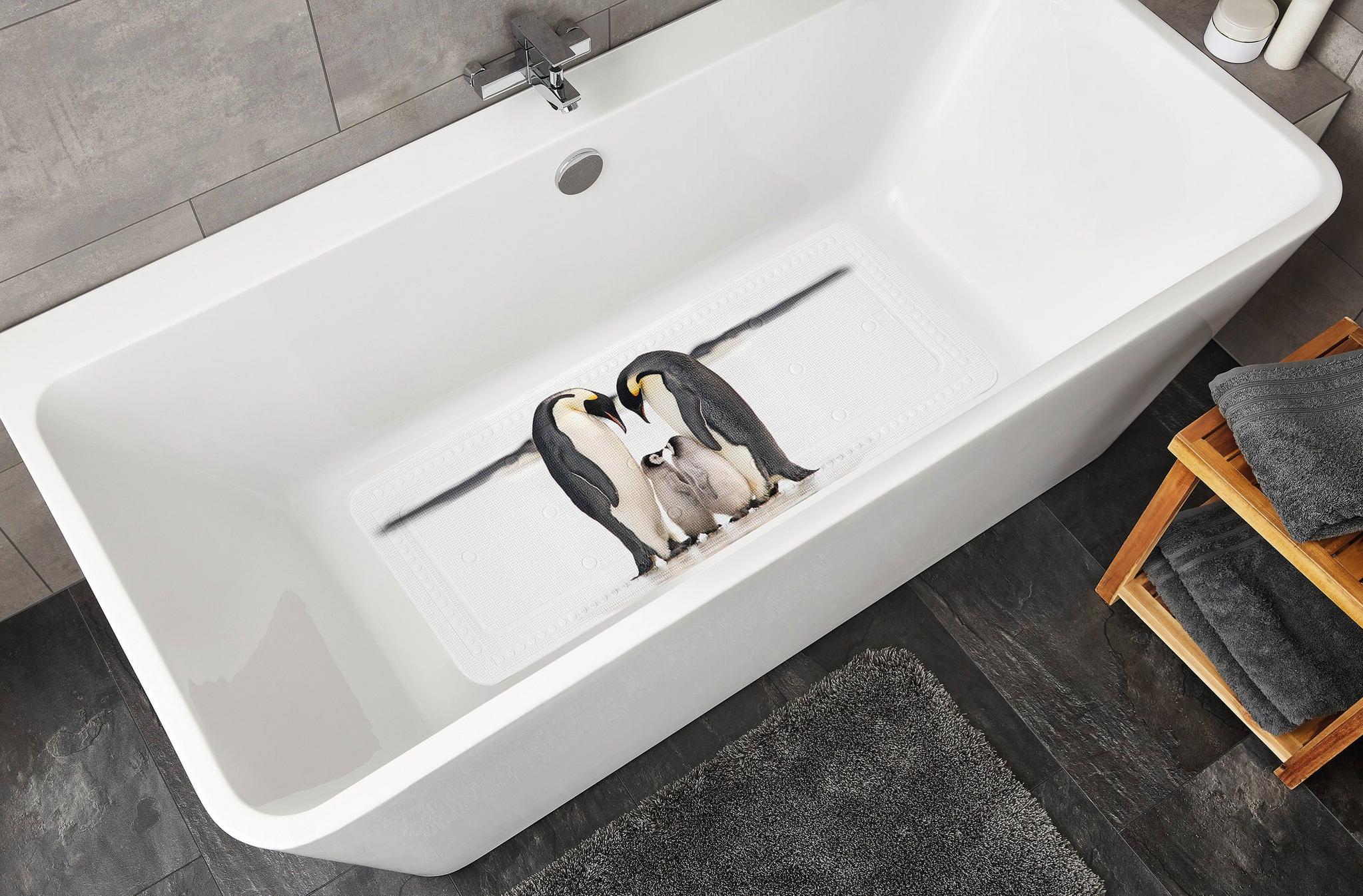 Weiße Badewanne mit rutschfester Matte und Pinguinfamilie im modernen Bad