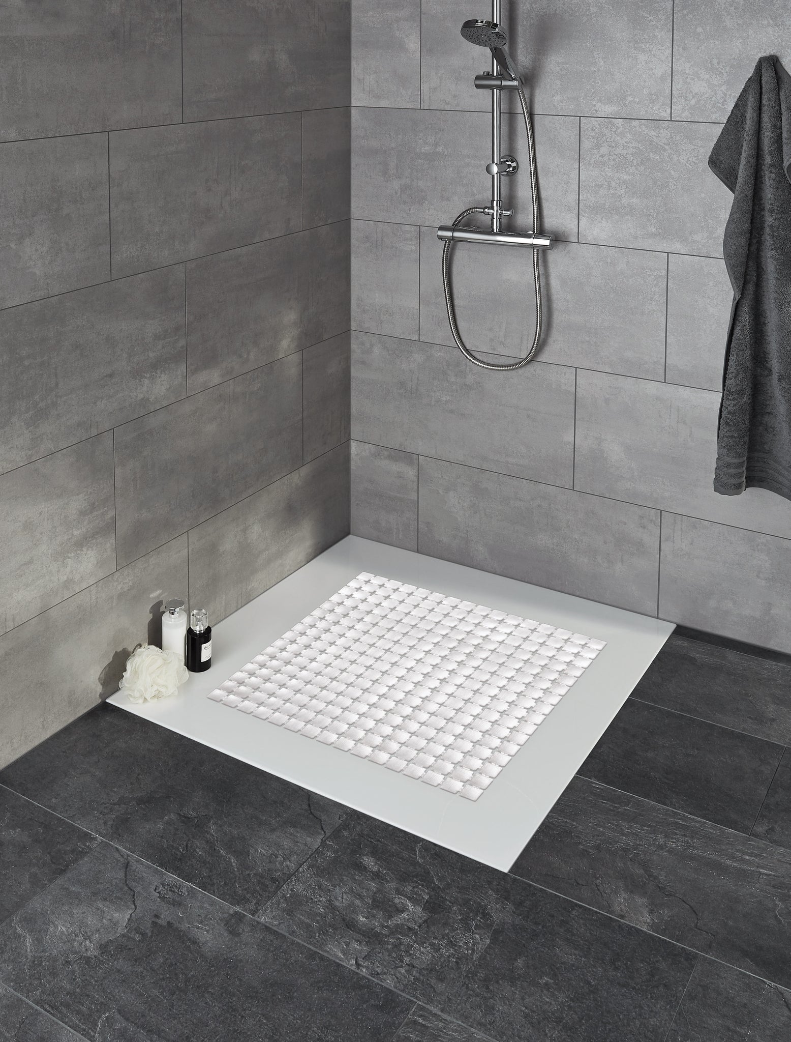 Duscheinlage GATTY Weiß 54x54 cm liegt in moderner ebenerdiger Dusche mit grauen Fliesen.