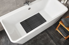 Weiße Badewanne mit schwarzer rutschfester Matte und grauen Handtüchern