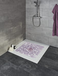 Dusche mit lila Badematte mit Blumenmotiv auf weißer Duschfläche