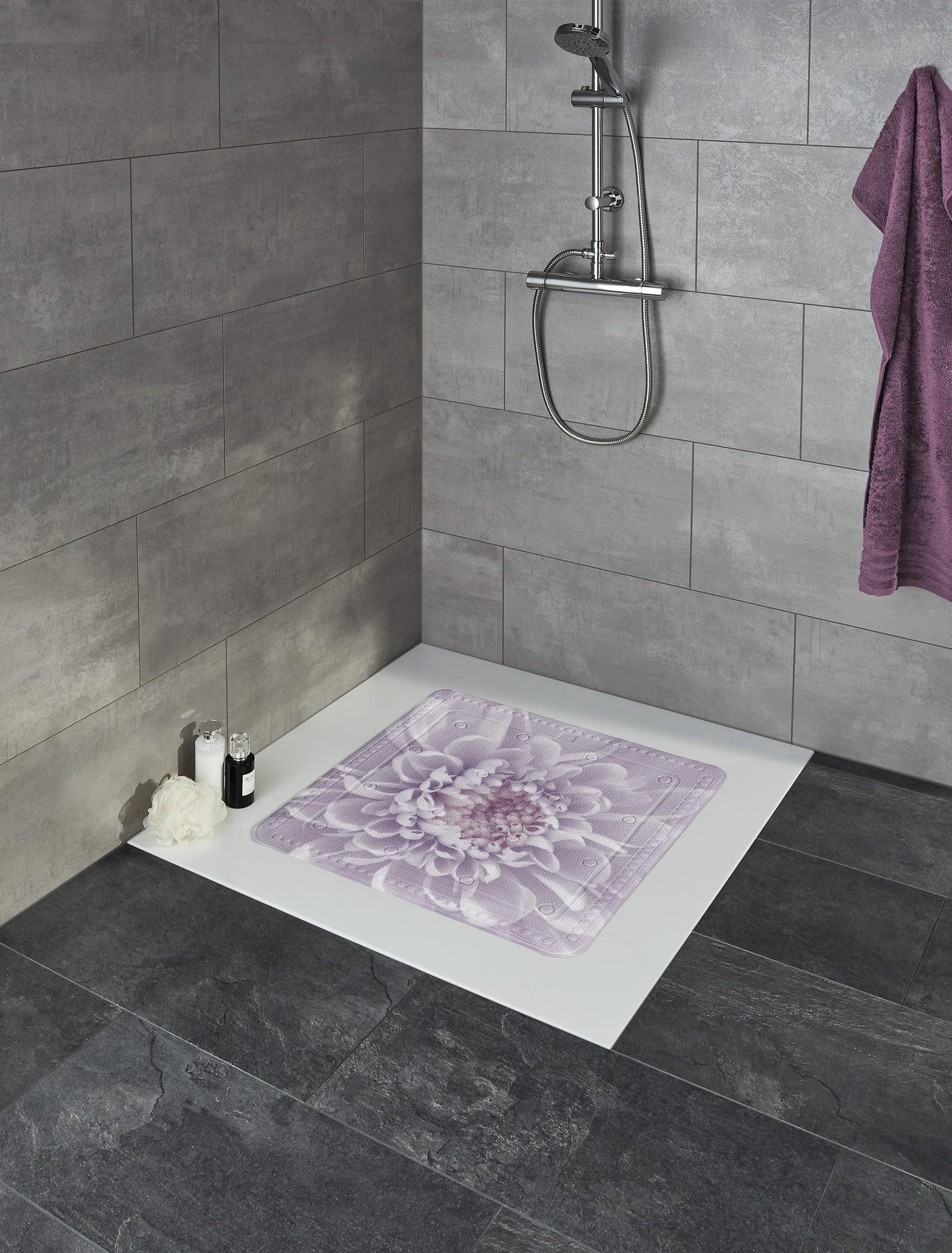 Dusche mit lila Badematte mit Blumenmotiv auf weißer Duschfläche