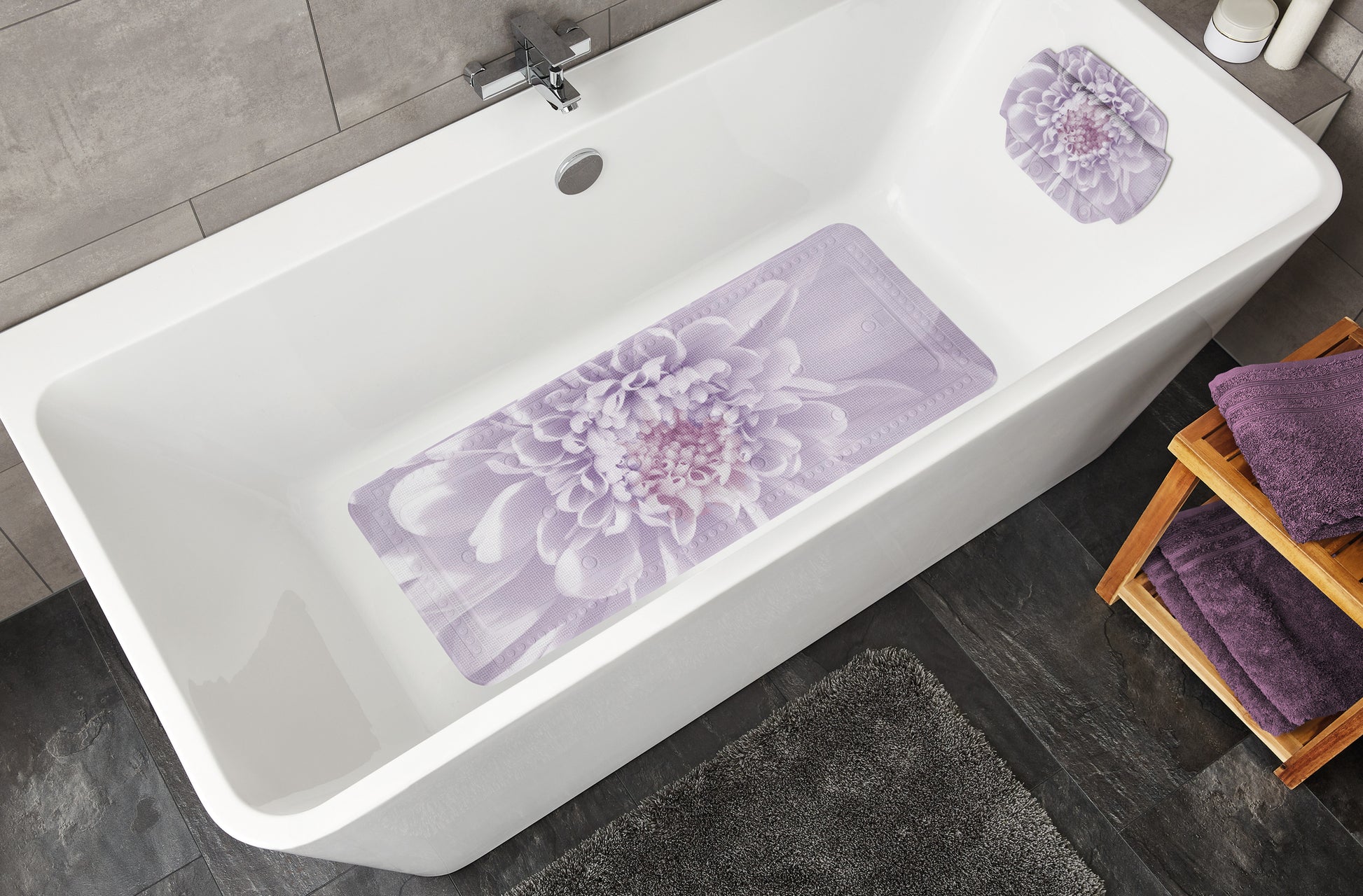 Weiße Badewanne mit lila Badematte, Kissenauflage mit Blumenmotiv