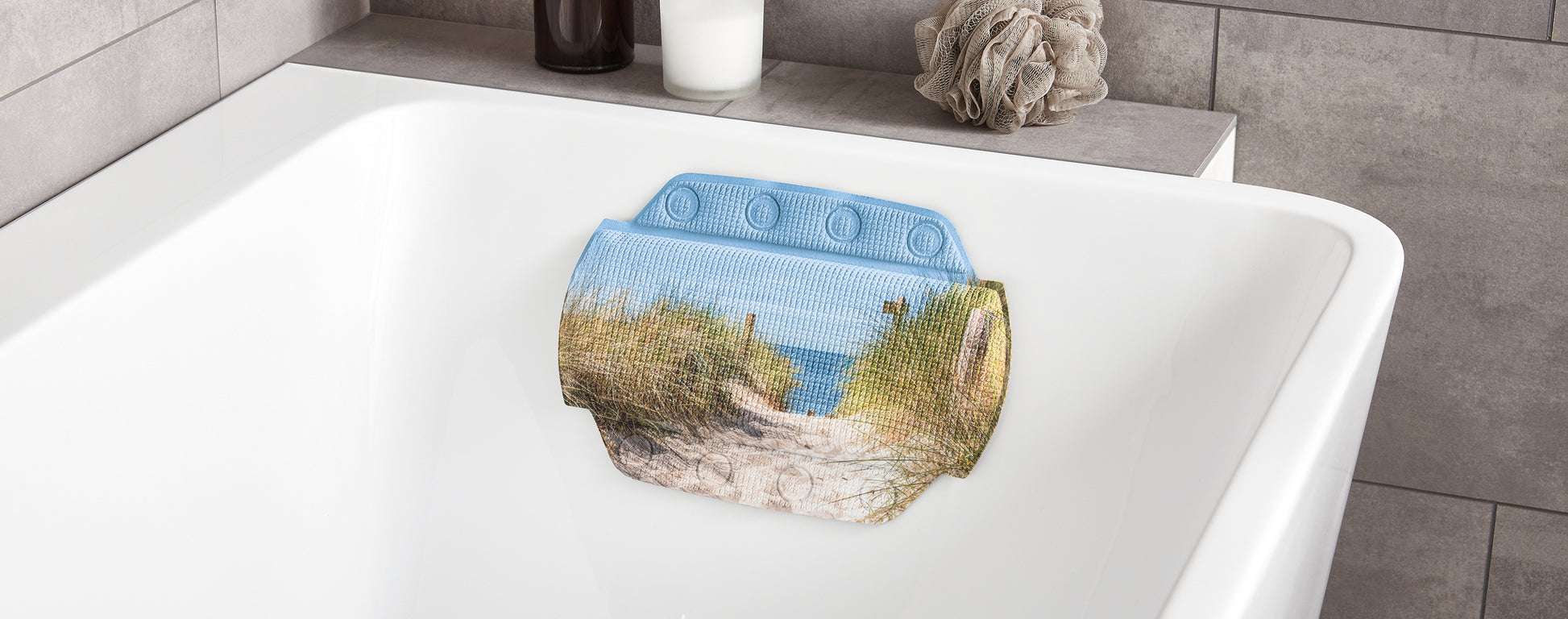 Das Nackenpolster BORKUM Multicolor 32 x 22 cm an weißer Badewanne mit Küstenmotiv und Badaccessoires.