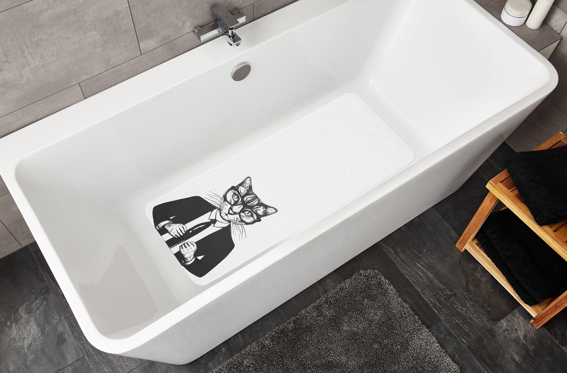Weiße Badewanne mit rutschfester Badematte mit Katzenmotiv innen unten