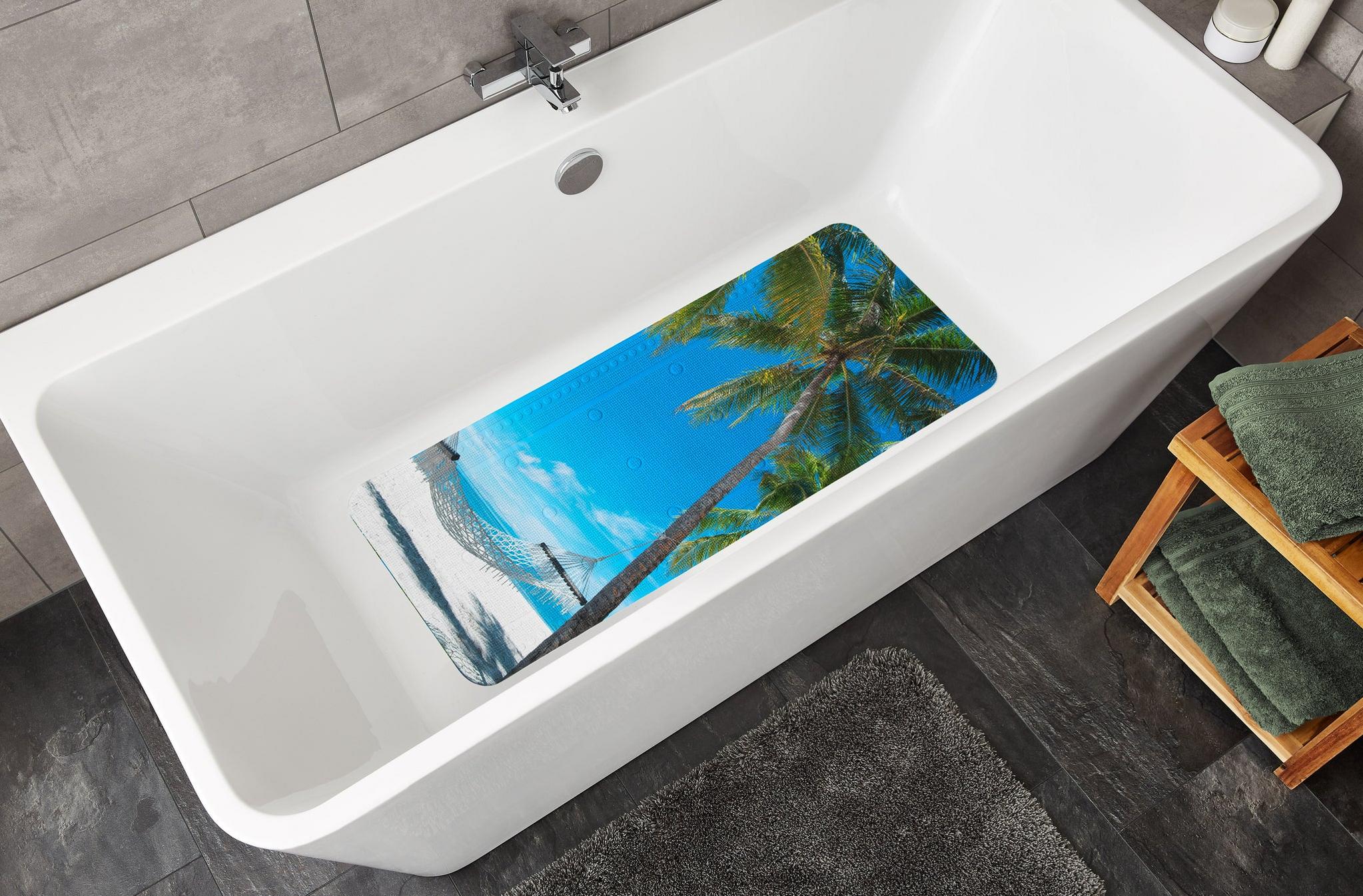 Weiße Badewanne mit bunter Antirutschmatte im Palmen-Strandmotiv
