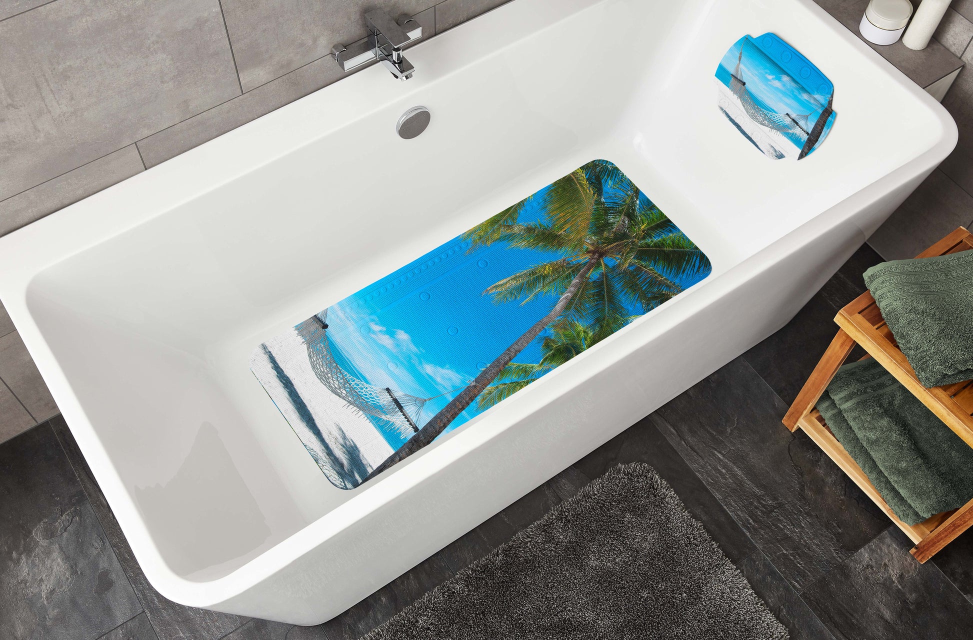In der Badewanne liegen Badematte und Nackenpolster BAHAMAS Multicolor mit Strandmotiv.