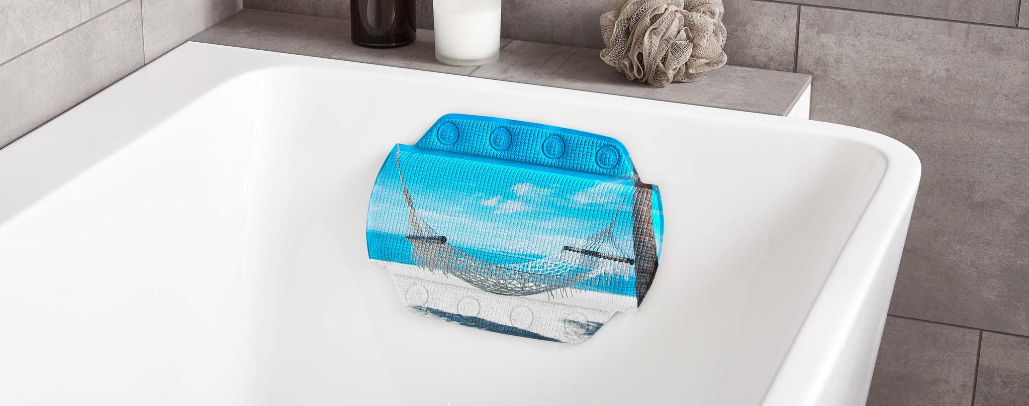 Blaues Badewannenkissen mit Strandmotiv an weißer Wanne im Bad angebracht