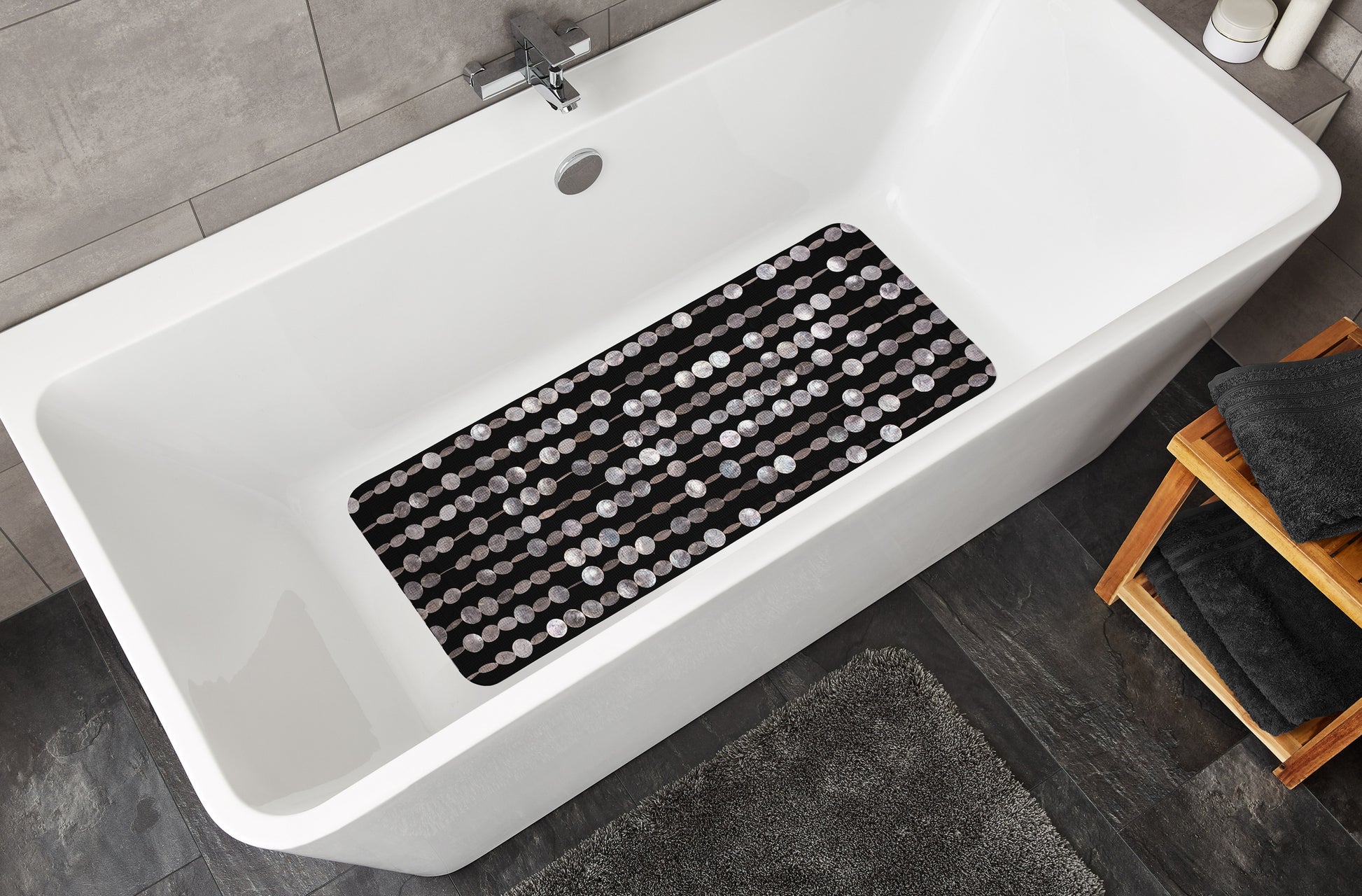 Schwarze Wanneneinlage PERLA 36 x 92 cm liegt in einer weißen Badewanne im modernen Badezimmer.