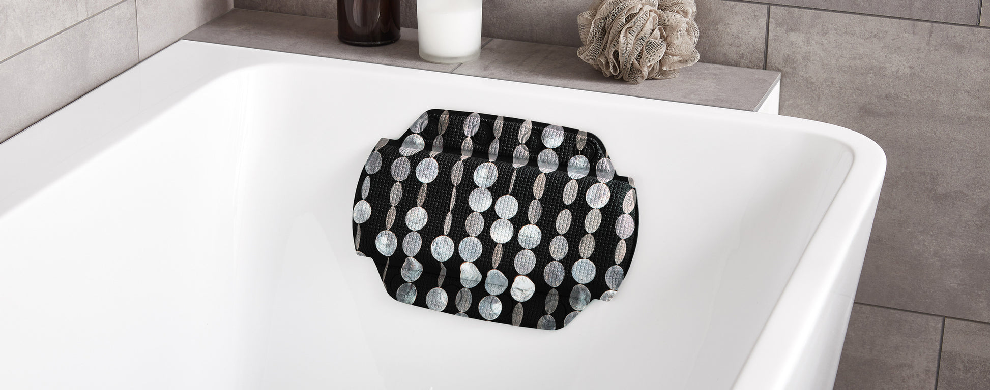 Nackenpolster PERLA Schwarz 32 x 22 cm liegt in einer weißen Badewanne im modernen Bad.