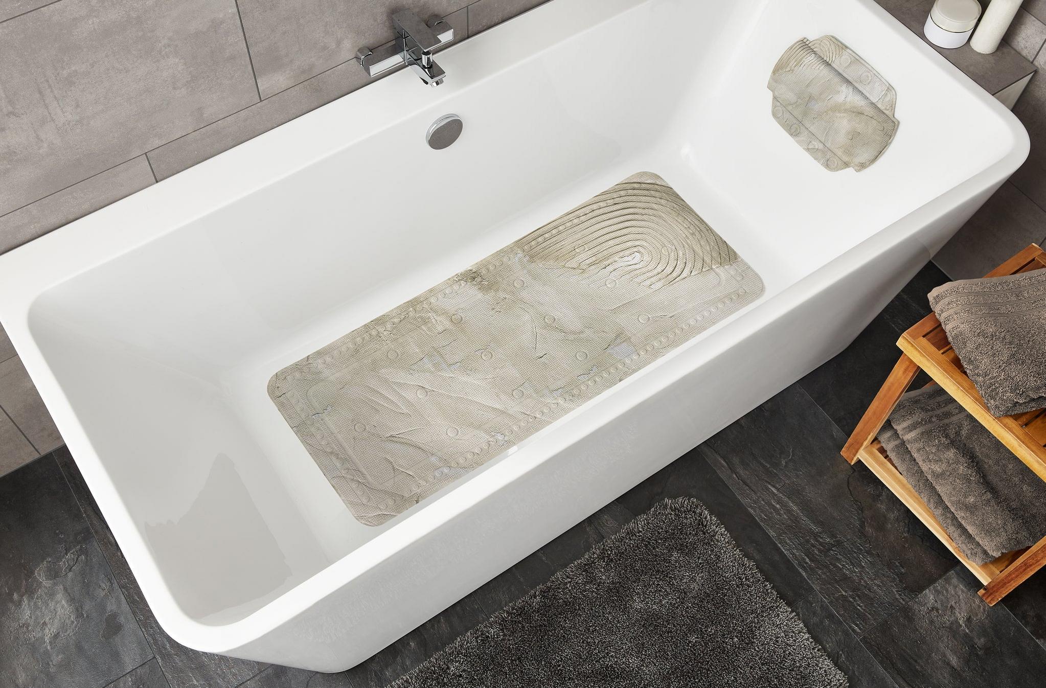 Weiße Badewanne mit rutschfester Badematte und grauem Badteppich