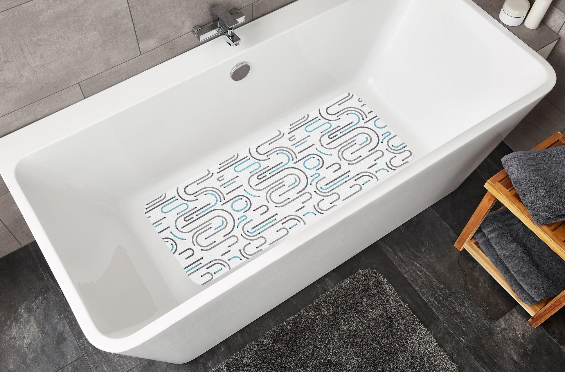Weiße Badewanne mit rutschfester Badematte in modernem Muster unten