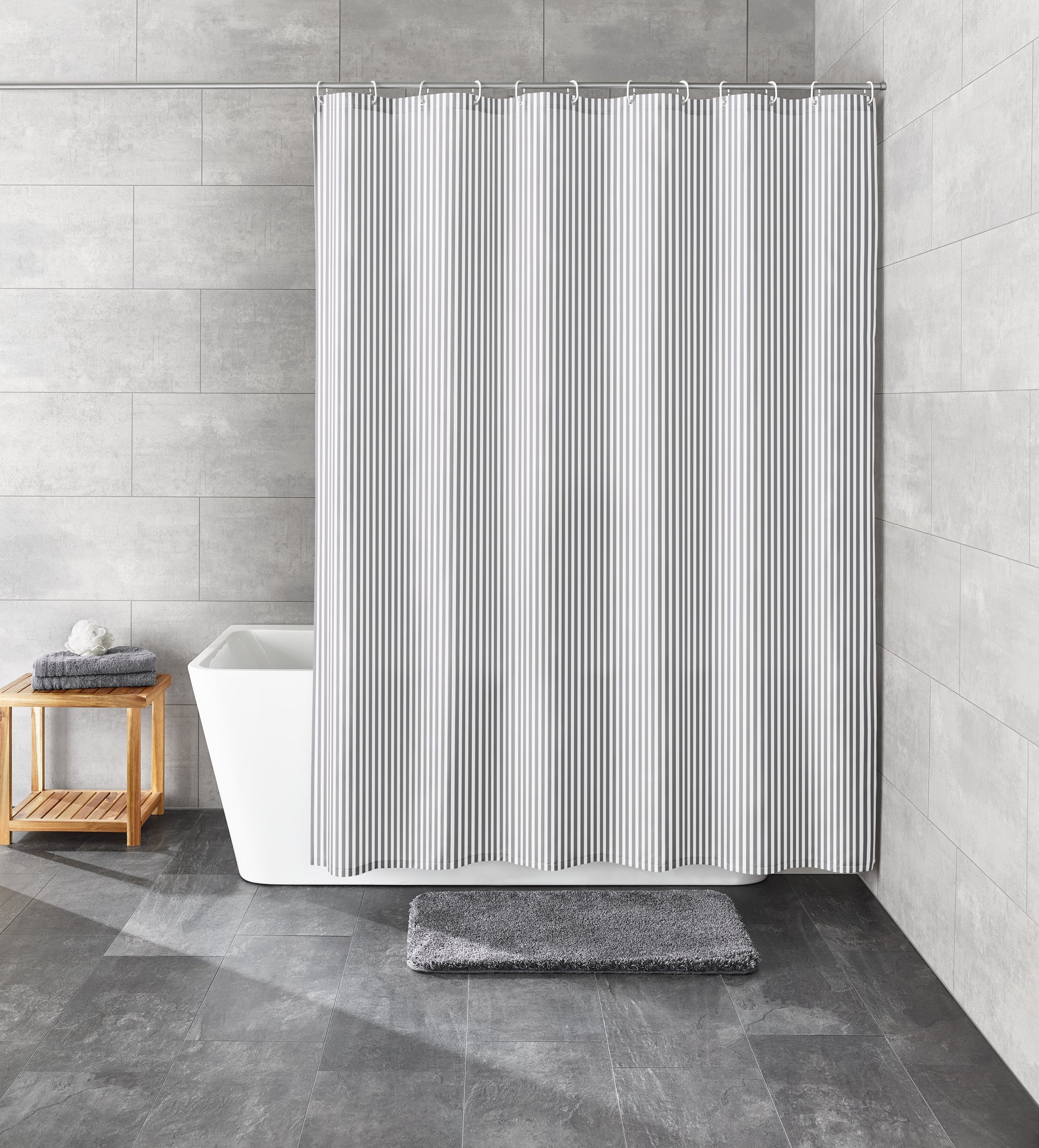 Grauer Duschvorhang Textil SANNA 120 x 200 cm hängt vor Badewanne in modernem Badezimmer.