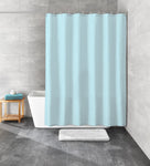 Hellblauer Duschvorhang vor weißer Badewanne in grauem Bad mit Badematte