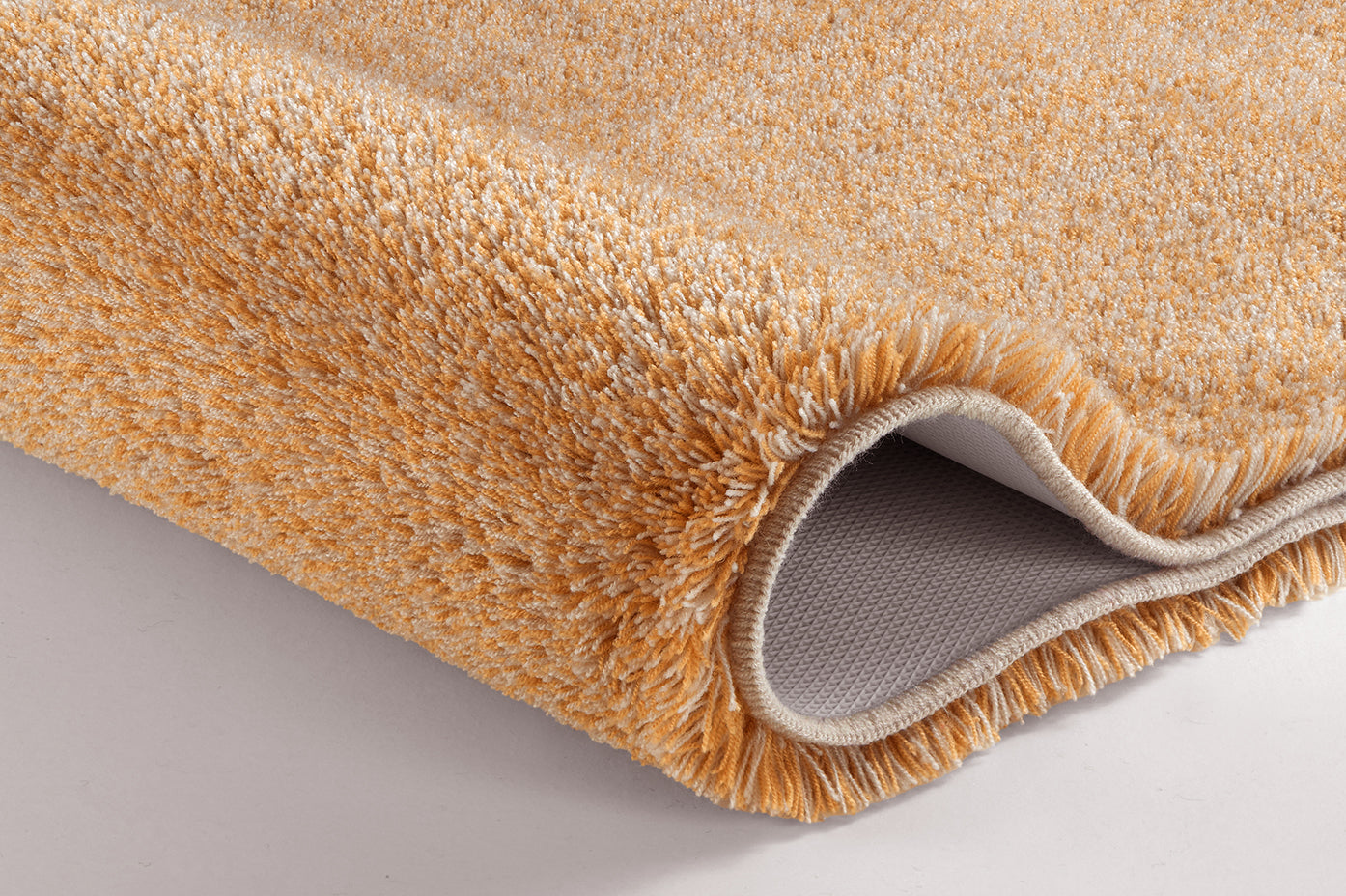 Nahaufnahme des peachfarbenen Badteppichs RELAX Peach aus dem 2-teiligen Set mit rutschhemmender Rückseite.