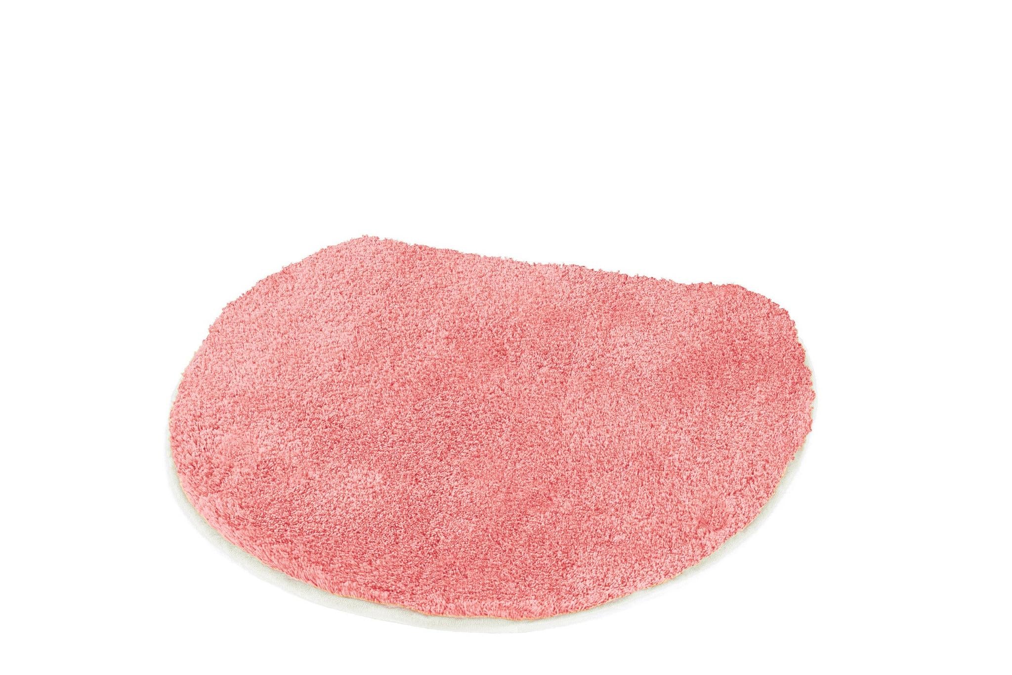 Halbrunder rosa Badvorleger aus Hochflor auf weißem Hintergrund