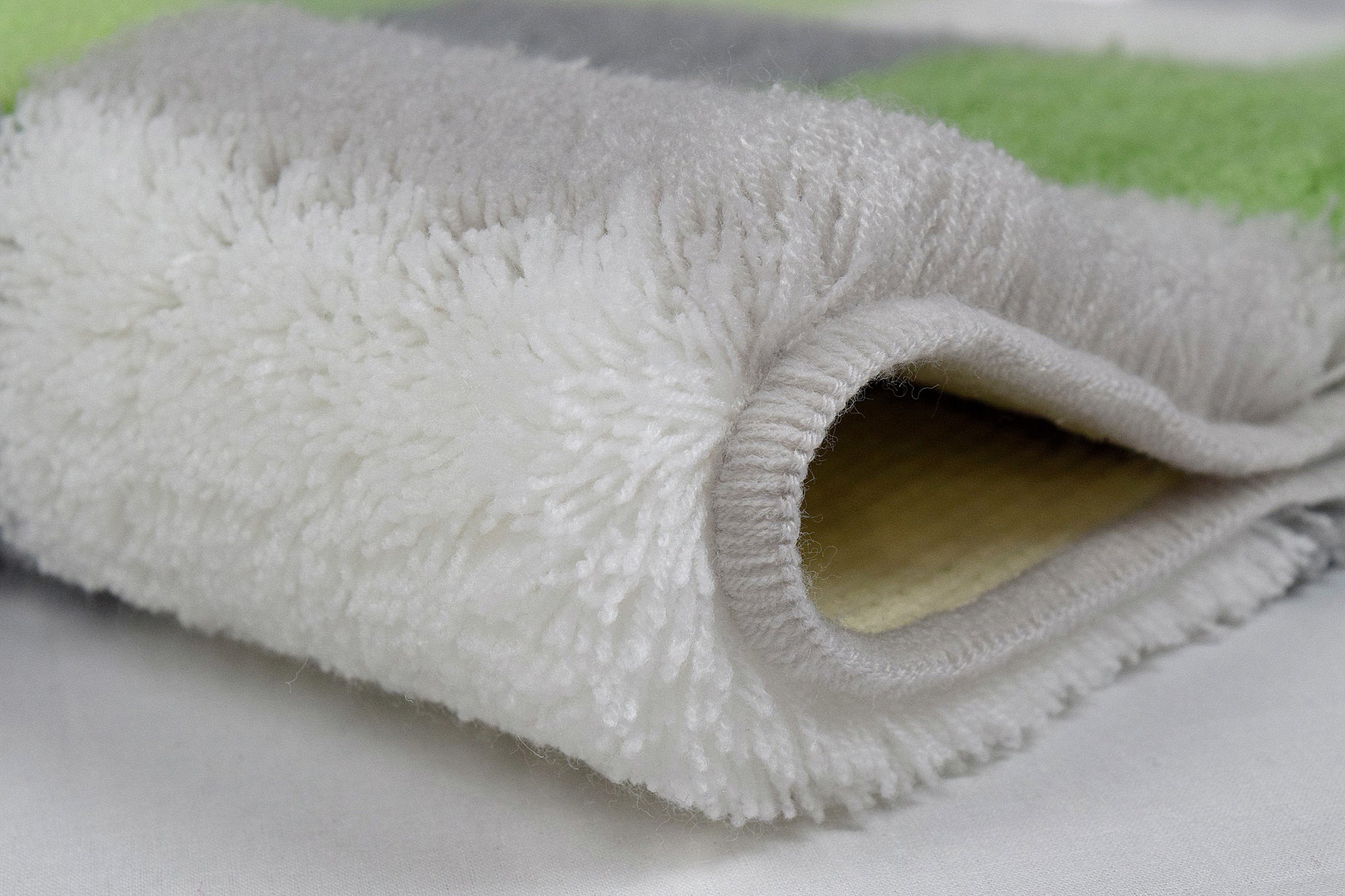 Nahaufnahme des gefalteten WC-Vorlegers CARO Distel 55 x 55 cm mit weichem Flor.