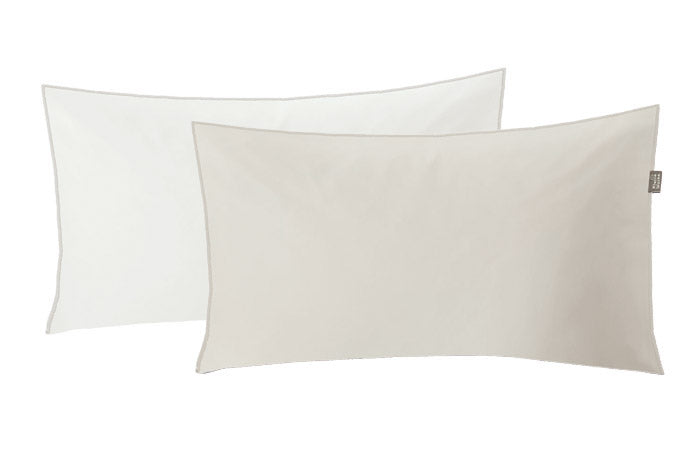 Zwei rechteckige Satin Kissenbezüge LINDA in Weiß und Beige im Format 40 x 80 cm liegen nebeneinander.