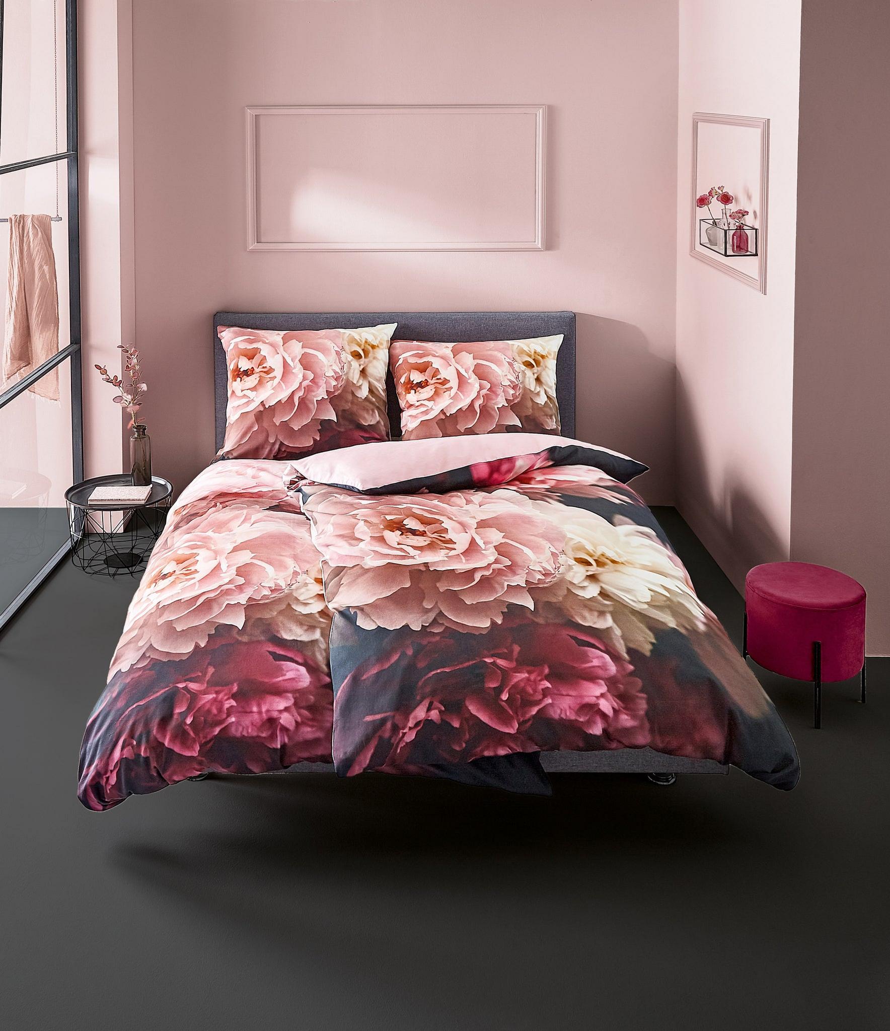 Doppelbett mit großer rosafarbener Blumenbettwäsche in modernem Zimmer
