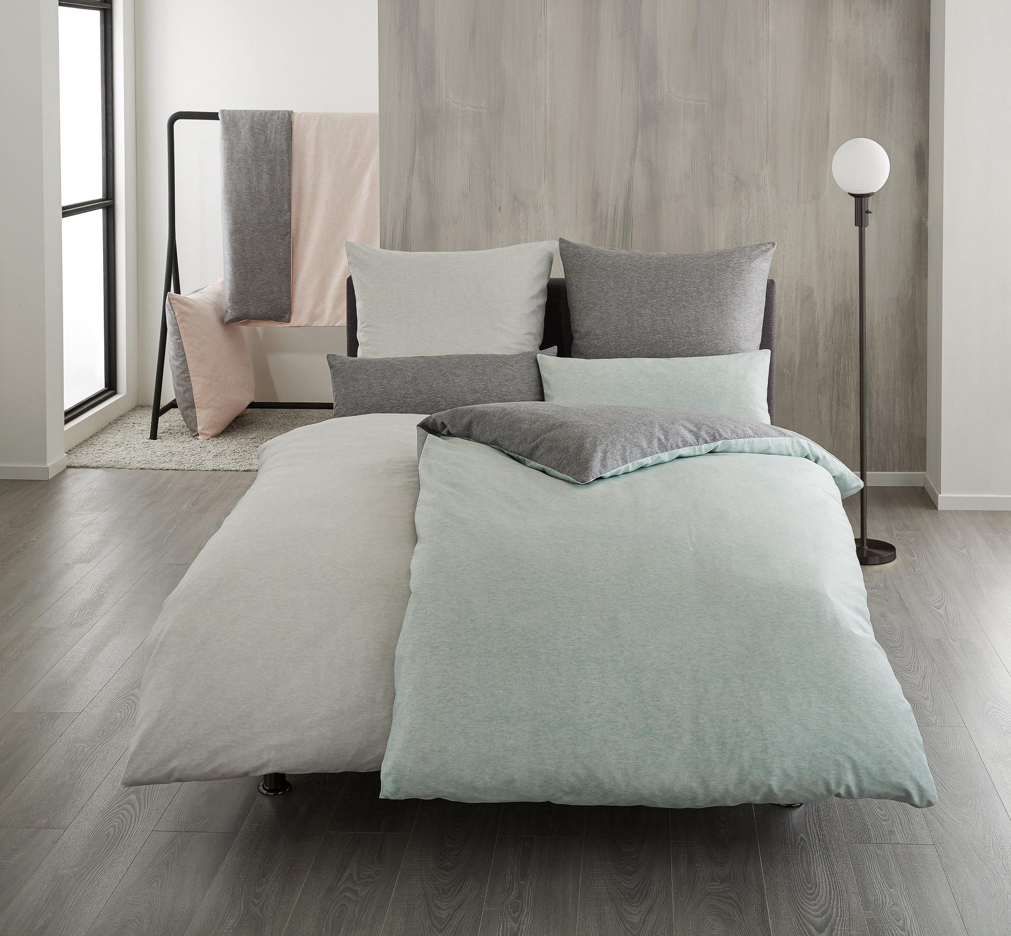 Modernes Schlafzimmer mit grauer und mintgrüner Bettwäsche und Kissen
