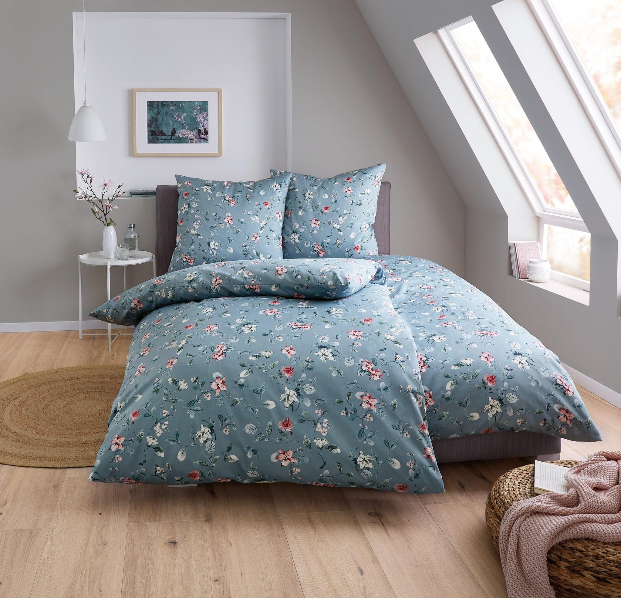Doppelbett mit blauer Bettwäsche im Blumenmuster in hellem Schlafzimmer