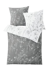 Bettwäsche Satin SAVANNAH Grau 135x200 und 80x80 mit weißem floralen Wendedesign ist abgebildet.