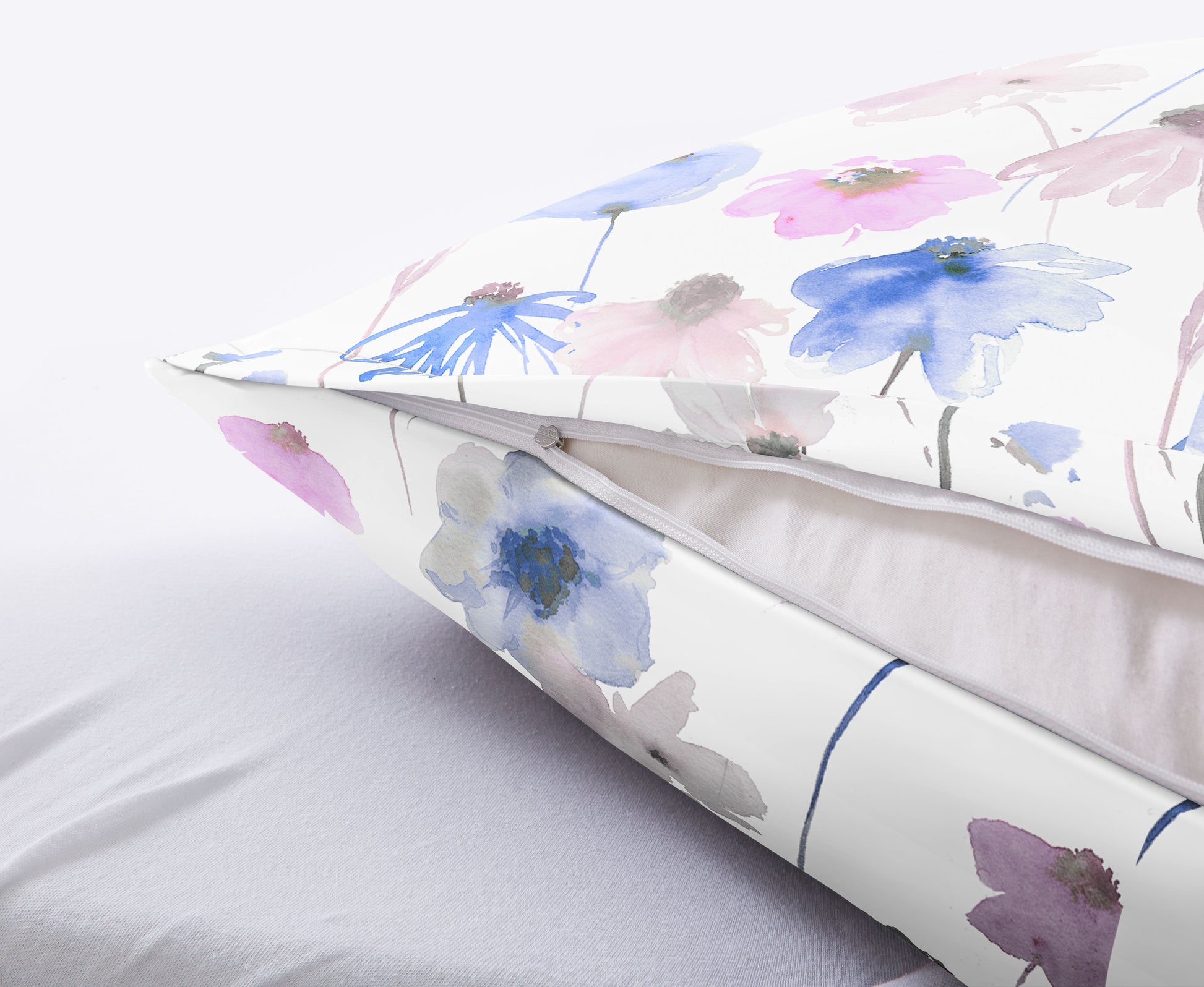 Kissen mit weißem Bezug und zarten Aquarellblumen in Pastellfarben