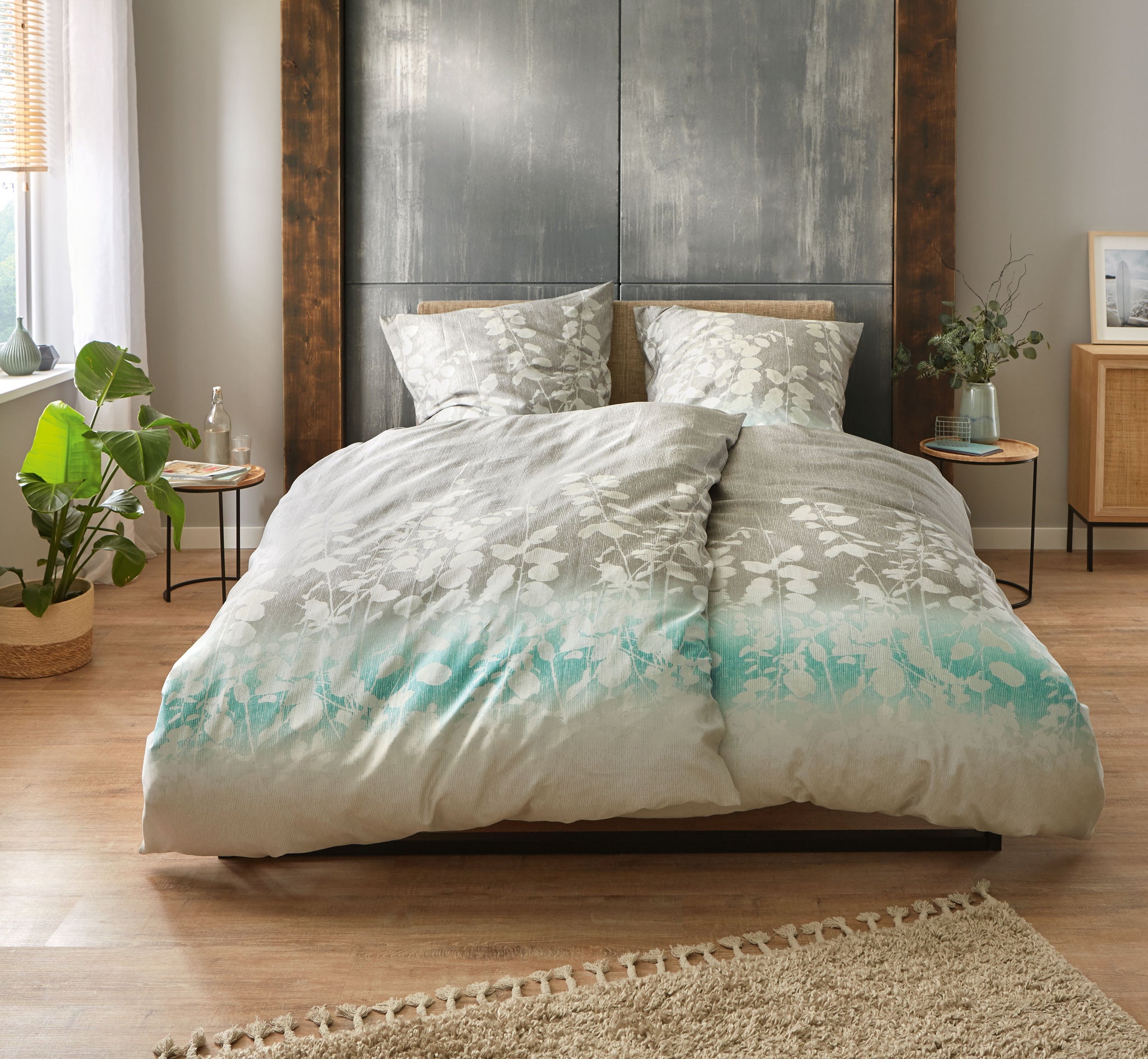 Bettwäsche Satin CALMARO Multicolor auf Doppelbett in modernem Schlafzimmer mit Pflanzen und Teppich.