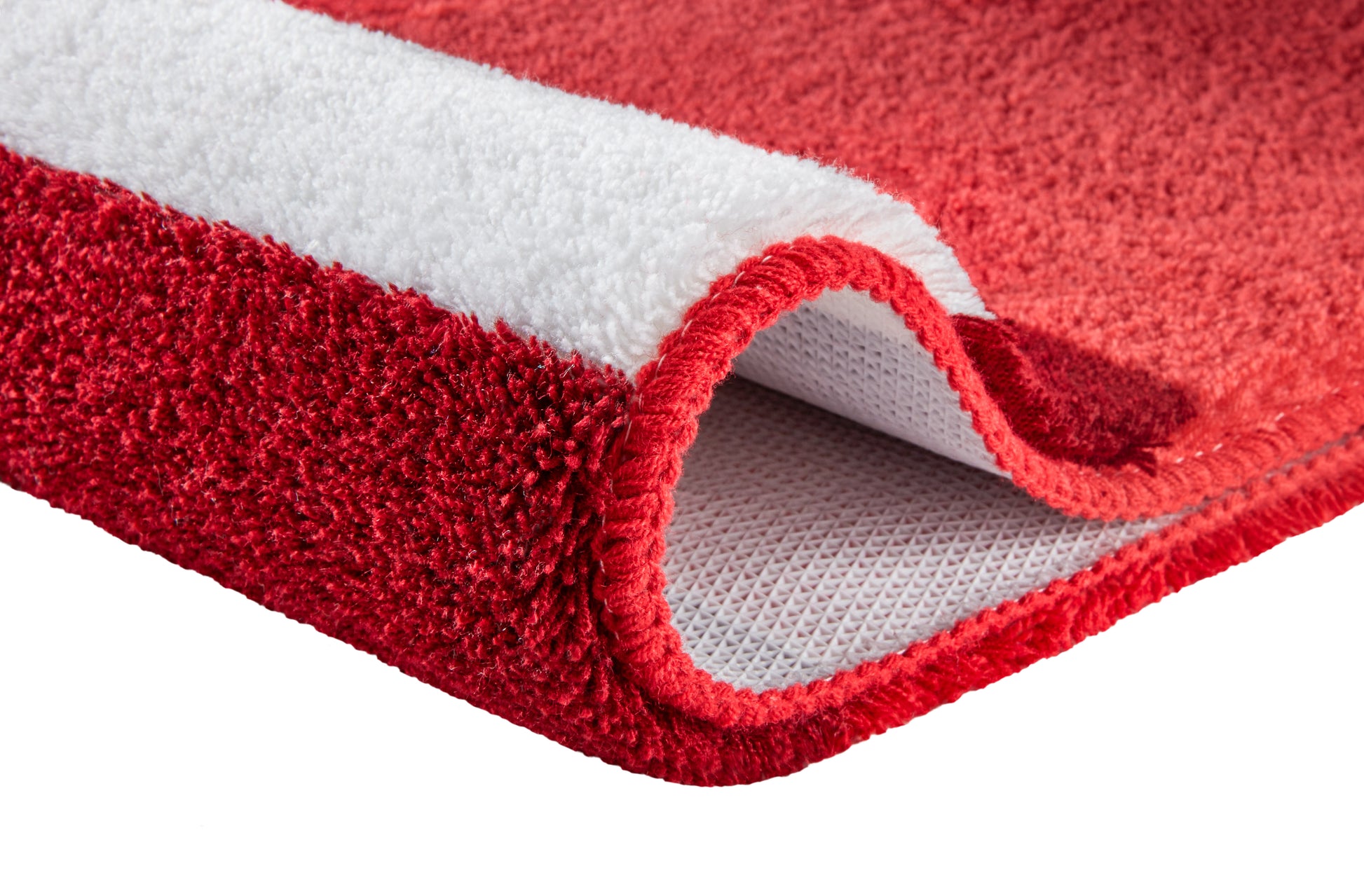 Roter Badteppich mit weißer Unterseite in Nahaufnahme.