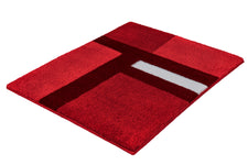 Rote Badematte mit geometrischem Muster in Rot, Bordeaux und Weiß.