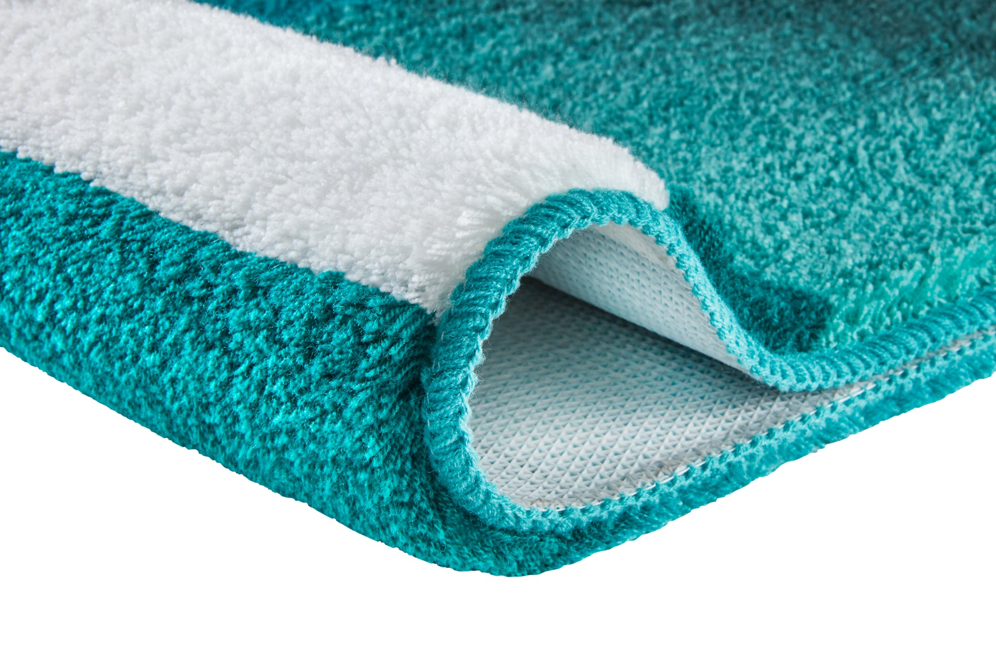 Türkiser Hochflor-Teppich mit weißer Unterseite im Detail.